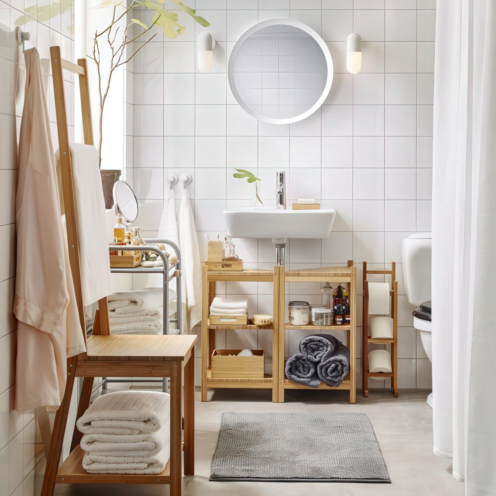 A chic contemporary bathroom done in neutrals and with simple furniture, with towels in the vanity and inside a stool.