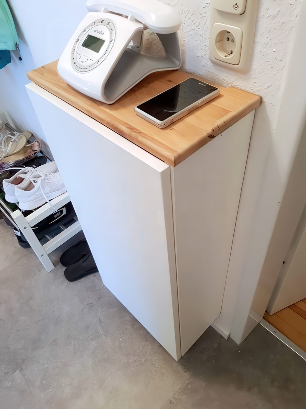 A tall and narrow wall-mounted storage unit can hide a router and some other stuff if you need it, and it won't take any floor space.