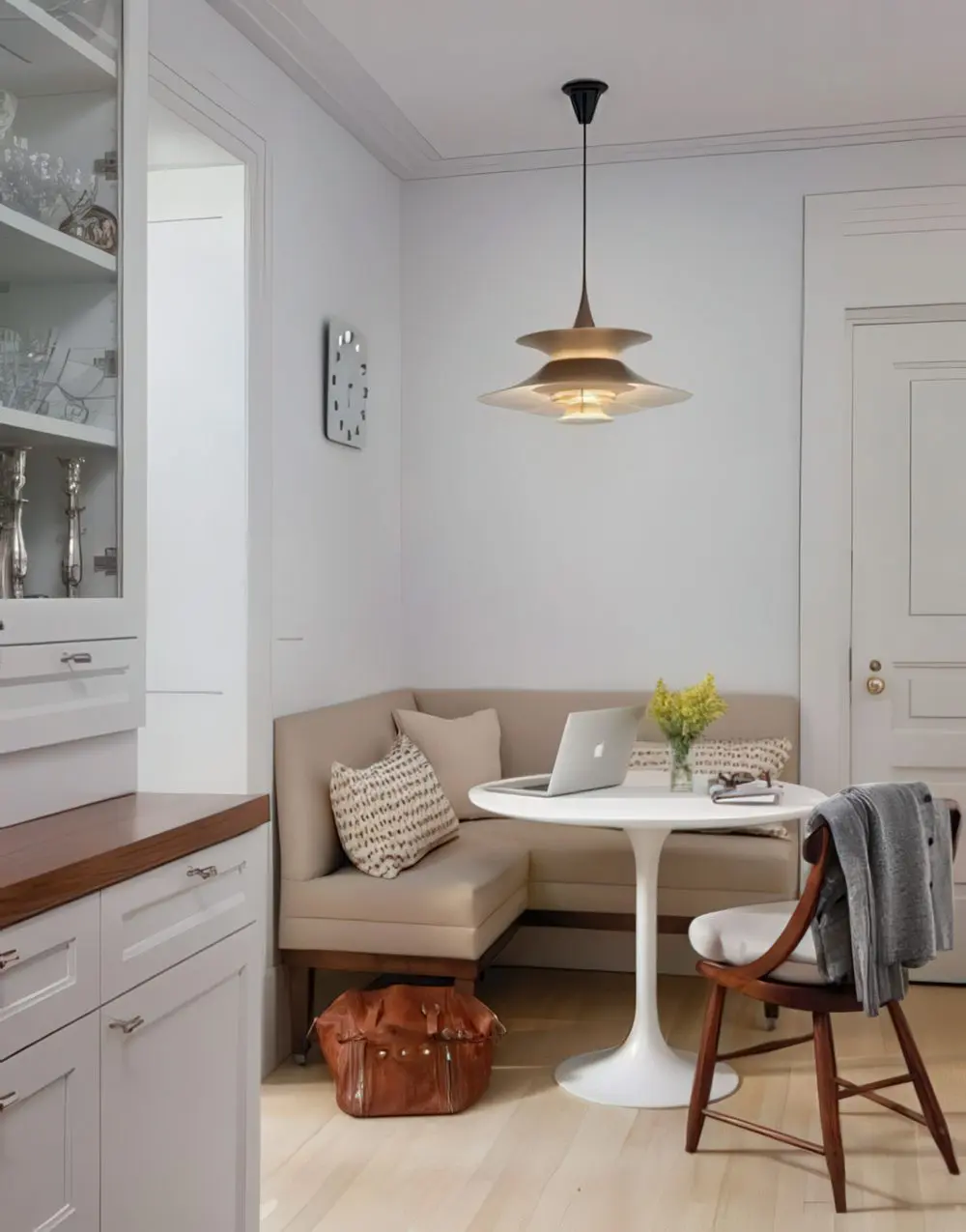 A cozy eating space in a small corner, a corner sofa and an eye-catchy hanging lamp over it.