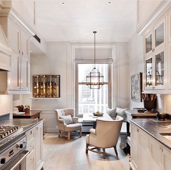 A gorgeous comfy eat-in nook with an upholstered bench, a table and a duo of armchairs for coziness.