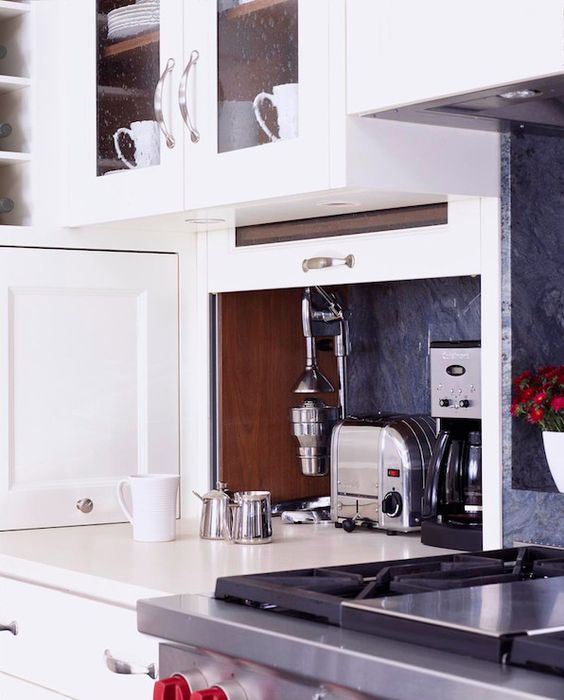 A tiny cabinet with a door that can go up and small kitchen appliances hidden inside is a lovely idea to achieve a sleek look.