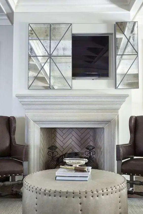 A vintage neutral living room with a fireplace clad with brick and a TV over it hidden behind antique mirror panels is a cool idea.
