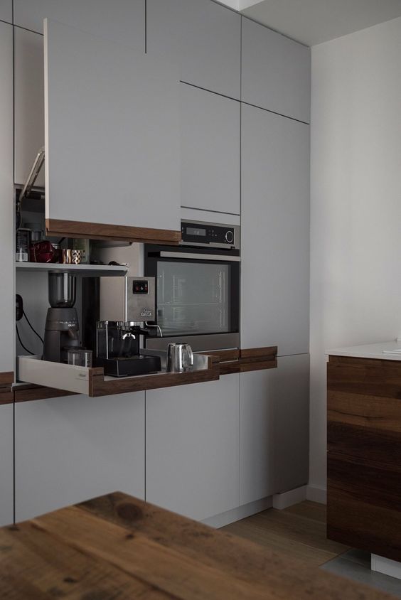 A cabinet with a lifting up door and retractable shelves holding various kitchen appliances is a great idea.