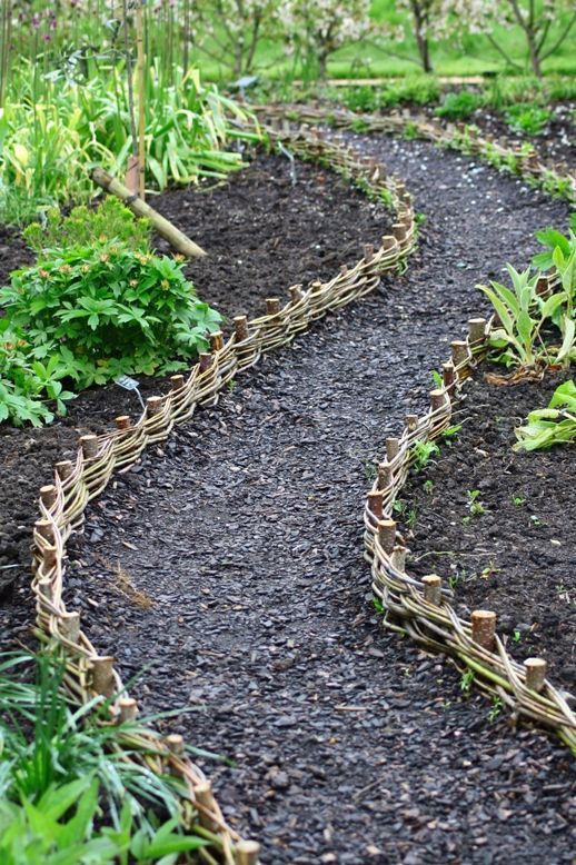 A woven garden border brings a rustic feel to the space and makes it cozy and welcoming.