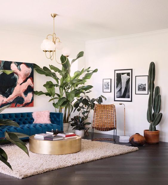 A bright artwork, pink pillows, lots of potted plants here and there make the living room fele like summer.