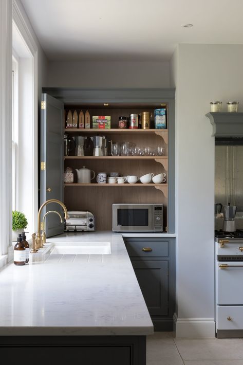 A cabinet with appliances, jars, mugs, cups and other stuff is a little coffee station that can be hidden with a folding door.