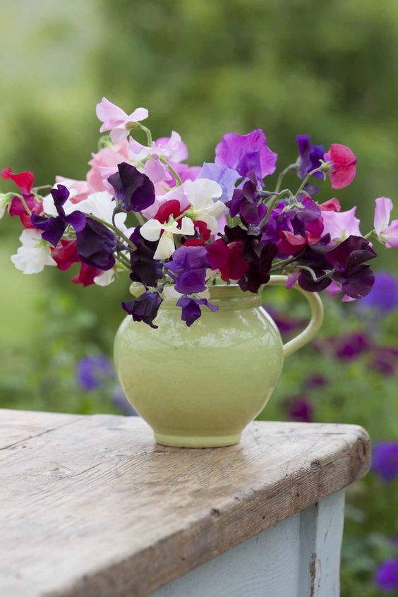 A green milkpot with bright florals is a nice rustic-style centerpiece or decoration for your summer space.