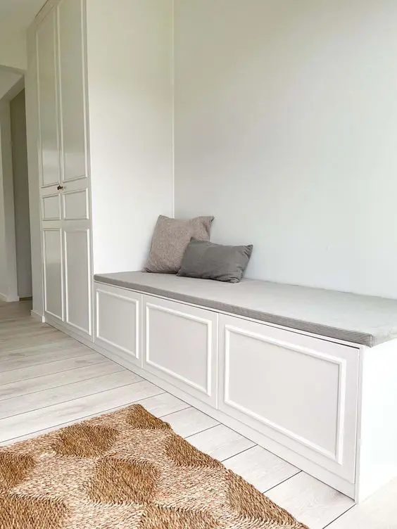 A large storage unit of a wardrobe and storage bench, the bench is built of IKEA Metod pieces.