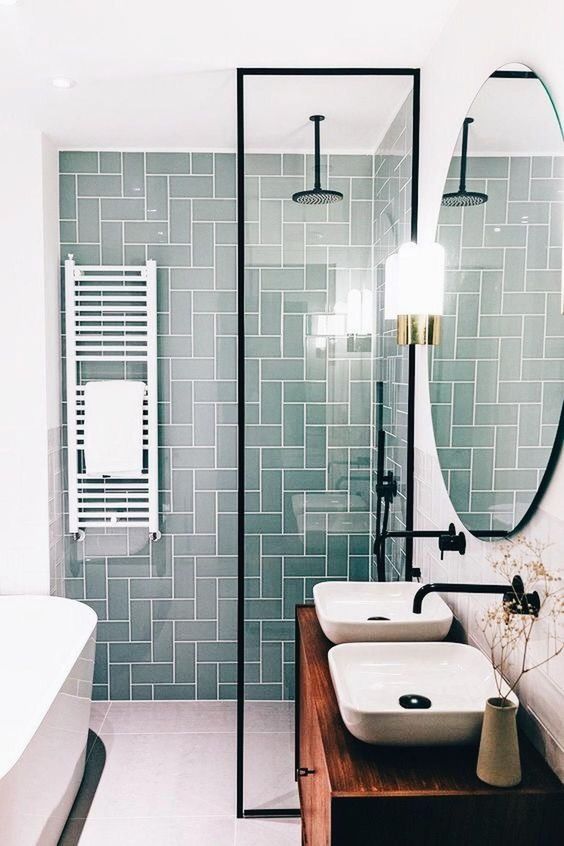 A small contemporary bathroom with a mint tile wall, a wooden vanity and touches of black for a modern feel.