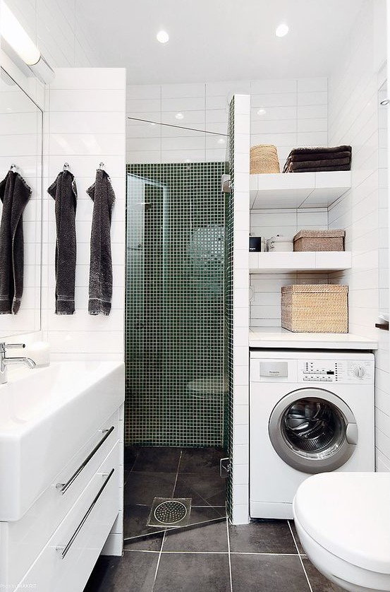 A tiny contemporary bathroom with a tiled shower space, a washing machine, a white vanity and a sink.