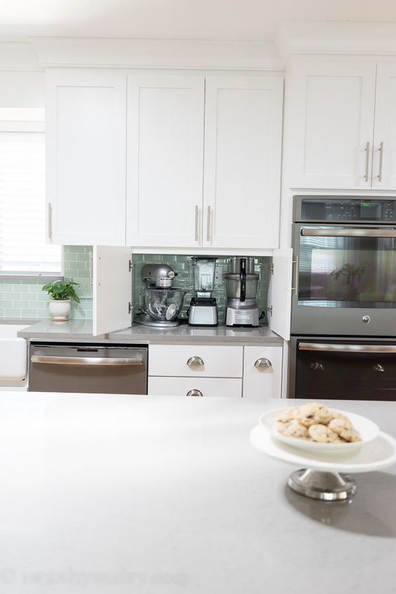 Built-in doors make this part of countertop a little cabinet for hiding appliances inside and decluttering the kitchen.