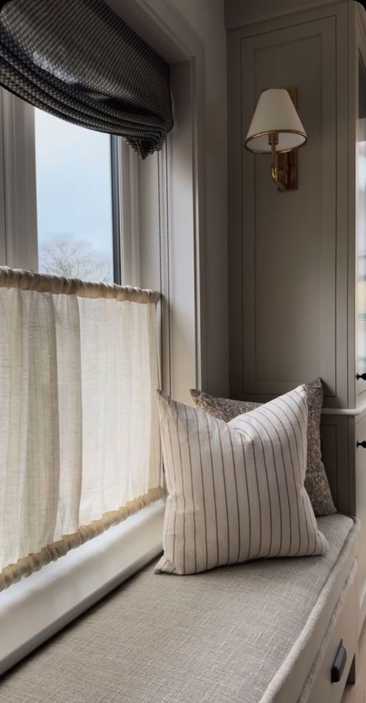 The window is done with shades and cafe curtains that still let light in.