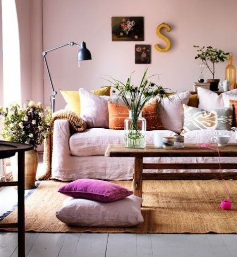 Soft pastel and muted color textiles, blush walls and lots of blooms in pots and vases bring a summer feel to the room.