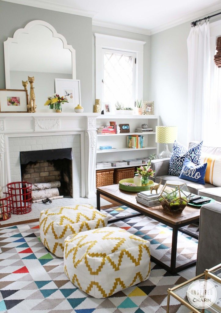 A bright printed rug, bold blooms, red baskets for firewood and some other colorful details make the space extra bold and summer-like.