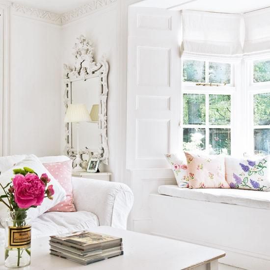 Some printed pillows and bold blooms will easily turn your neutral living room into a bright summer one.