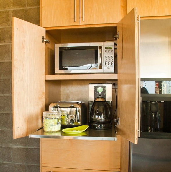 A light stained plywood cabient with several appliances and a retractable shelf is a very comfy idea to make your kitchen look neat.