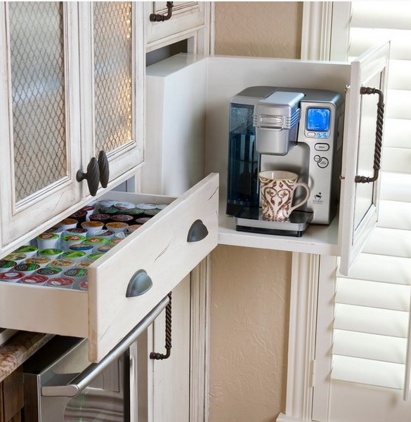 A large drawer with a removed part holds a coffee machine and a drawer next to it holds everything you may need for a coffee.