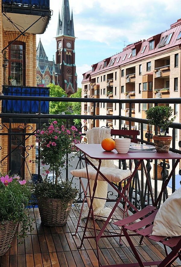A chic and fun summer balcony with pink metal furniture, potted greenery and blooms is a simple and chic space to enjoy fresh air.