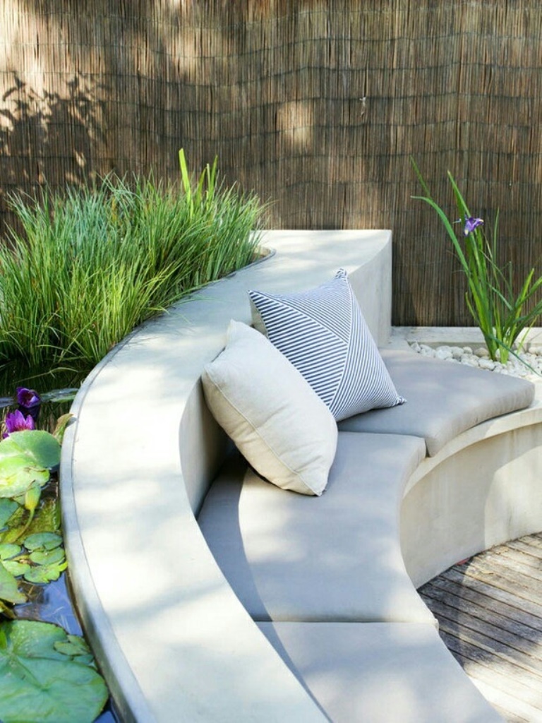 The minimalist space shows off a combo of a concrete bench and a pond behind its back.