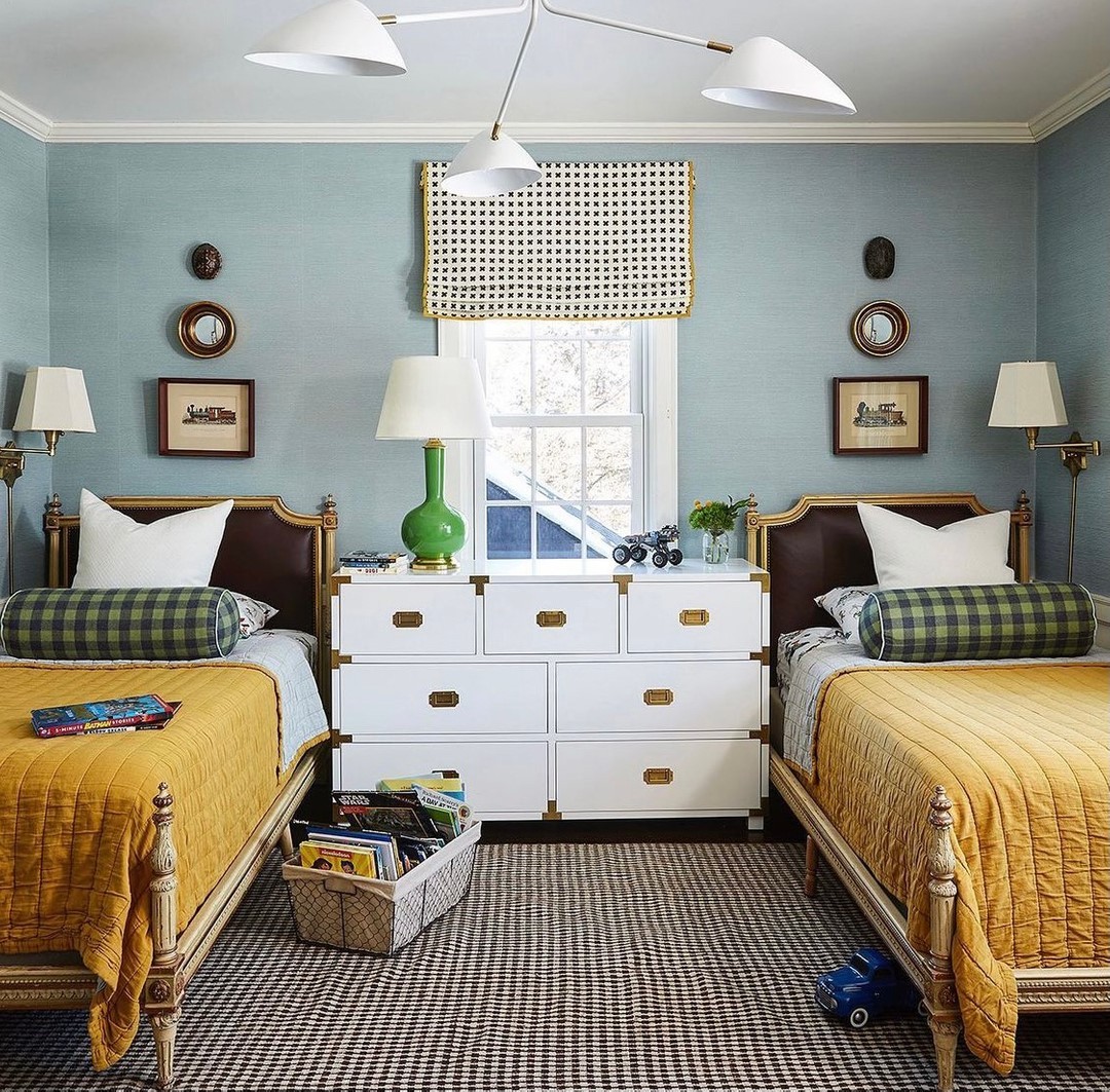 The space includes built-in beds separated by a partial wall with shelves for books and decor. The dark green walls contrast beautifully with the mustard yellow and white bedding, creating a warm and inviting atmosphere. The rustic accents and woodland-inspired details make it a charming retreat.

(@kiplinghouseinteriors).