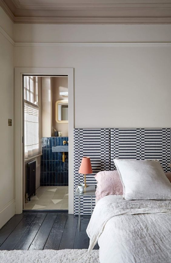 The bed is finished off with a printed extended headboard for more interest in the neutral space.